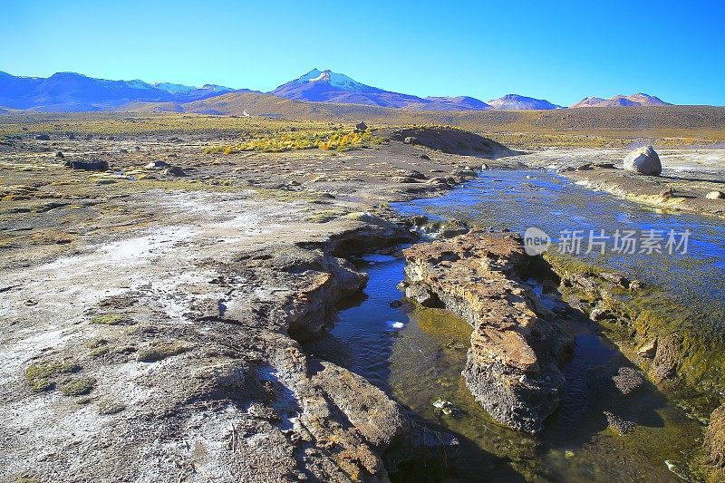 戏剧性的景观:Tatio Geysers河流在日出和田诗式的阿塔卡马沙漠草原，积雪覆盖的火山景观全景-圣佩德罗阿塔卡马，智利，Bolívia和阿根廷边境